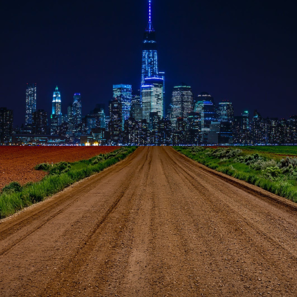 combination image of a dirt road leading to a vibrant city at night