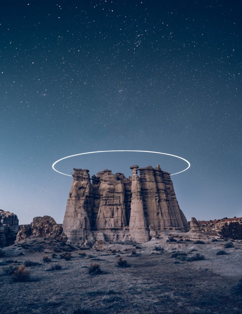 stone formation in desert under stars with light ring