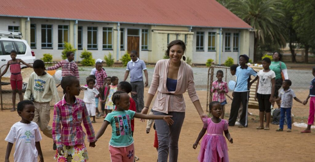 smiling woman helping children